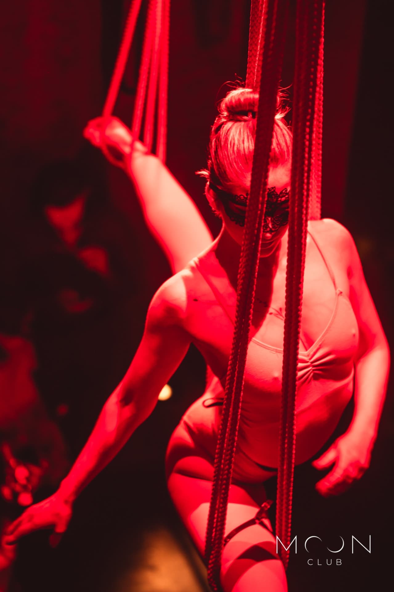 Cabaretní vystoupení v Moon Clubu – maska, červené světlo